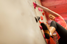 Young Woman Exercising At Indoor Climbing Gym