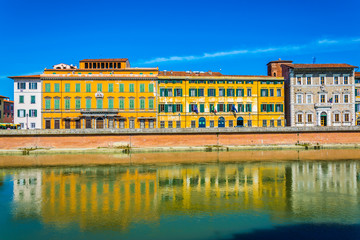 Wall Mural - Historical buildings stretched alongside river Arno in the historical center of the italian city Pisa.