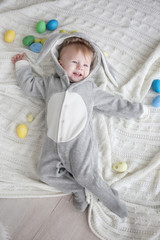 Sticker - Cute little baby in bunny costume lying on cozy plaid