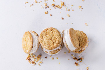 Set of homemade ice cream sandwiches in oat cookies with almond sugar crumbs over gray texture background. Top view with space