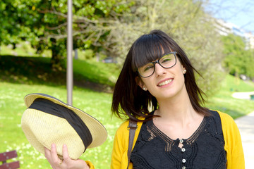 portrait of young brunette girl with summer hat in park