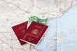 © ajcabeza - Spanish passports with european union currency on a map background. Travel concept.