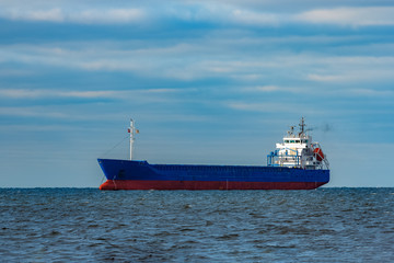 Blue cargo ship moored in still Baltic sea water