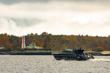 Wall Mural - Black elite speed motor boat entering Riga