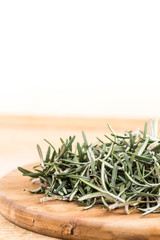 Sliced and chopped rosemary plant on the wooden board