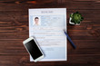 © Africa Studio - Resume and phone on wooden table