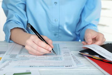 Woman filling form of Individual Income Tax Return, closeup