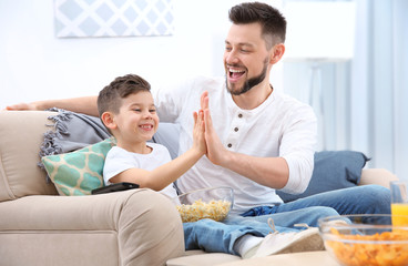 Wall Mural - Father and son watching sports on TV at home