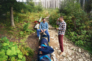 Wall Mural - Two hikers taking a break from trekking in the forest