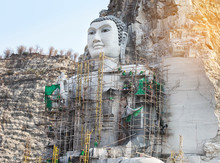 Big Buddha Carved From Stone On The Mountain Under Construction In Public Thai Temple At Suphanburi Thailand  
