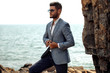© ASjack - Man in elegant suite posing in rock background