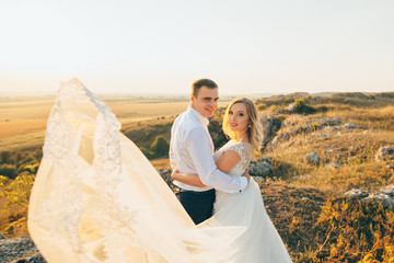 Wall Mural - stylish gorgeous couple newlyweds standing on the rocks in the mountains