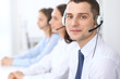 © rogerphoto - Call center operators. Focus at businessman in headset while consulting customers.