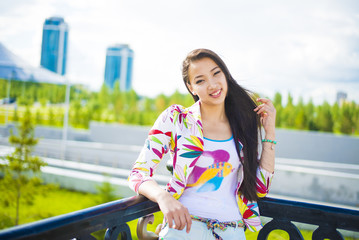 Astana city urban woman enjoying view of  bridge  skyline living a happy lifestyle walking during summer travel in asia. Female Asian tourist in her 20s. smiley happy face