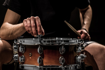 man adjusts a percussion instrument, musical concept with the working drum