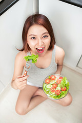 Wall Mural - Beautiful young asian girl eating salad. smiling happy girl eating healthy food.