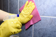 Scrubbing tiles in the kitchen with yellow gloves