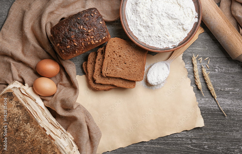 Blank paper sheet and ingredients for cooking bread on wooden background