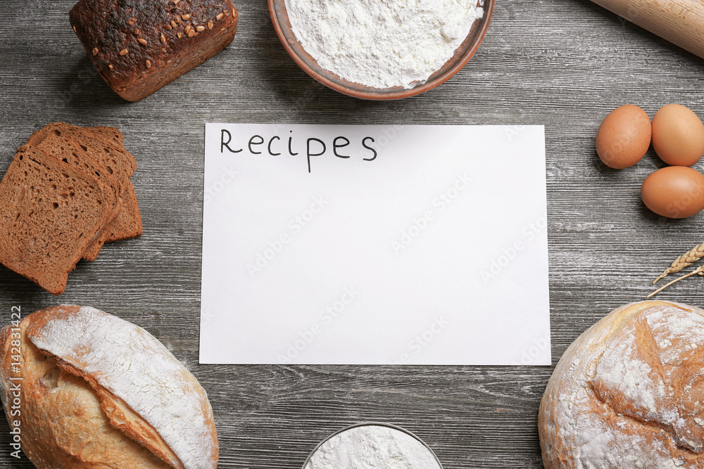 Blank paper sheet and ingredients for cooking bread on wooden background