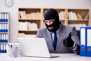 Criminal businessman with balaclava in office