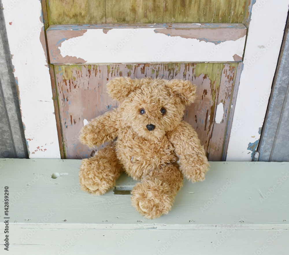 Child's teddy bear toy sitting on a bench. Stock Photo | Adobe Stock