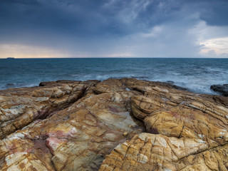 View of a stony shore of the sea under the heavy stormy sky