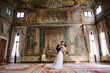 Bride and groom in a room with frescoes in Venice