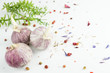 Drei Knollen Knoblauch mit Beeren, Kräutern und Lavendelblüten auf weißen Hintergrund, Textfreiraum