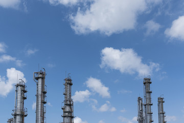 Refinery column with cloudy blue sky