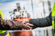 © Photocreo Bednarek - Business handshake in a shipyard. Shipbuilding industry