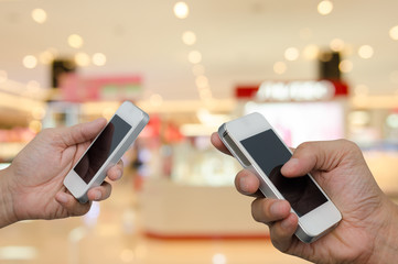 Two men holding mobile smart phone.