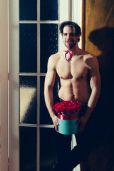 Wall Mural - bearded muscular man with sexy body holds red rose box