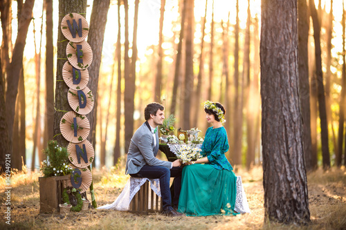 Rustic Wedding Bride And Groom Sitting Near Decorated Table