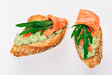 Two bruschettes with arugula in fillet of tuna and green sauce