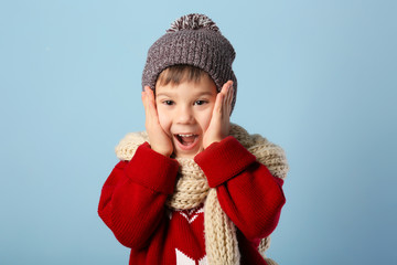 Wall Mural - Cute little boy in warm clothes on color background