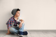 © Africa Studio - Cute stylish boy sitting on floor near light wall