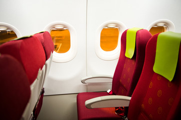 empty airplane interior with  red seats and window.