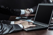 © yurolaitsalbert - closeup of businessman working on laptop on background of business partners handshaking