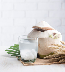 Wall Mural - Coconut juice,Drink coconut water on table against white brick wall