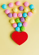 photo of tasty colorful marshmallows and heart shaped box on the wonderful yellow background