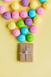 photo of tasty colorful marshmallows and cute gift on the wonderful yellow background