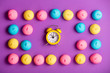 photo of tasty colorful marshmallows and alarm clock on the wonderful purple background