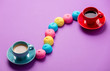 photo of tasty colorful marshmallows and cups of coffee on the wonderful purple background