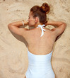 Seen from behind woman in swimsuit laying on the sand