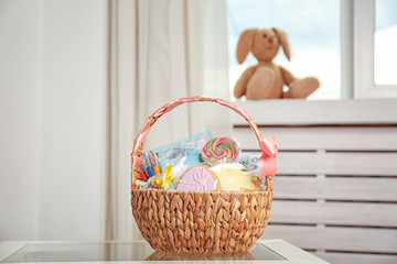 Wall Mural - Easter basket with sweets and stationery on light background