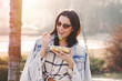 © sakkmesterke - Young brunette woman in sunglasses eating fresh salad outdoor