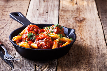 Meatball penne pasta with spicy tomato sauce and dill