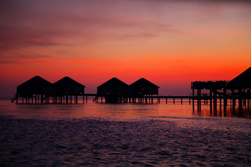 Wall Mural - silhouette of water bungalows at twilight, beautiful landscape