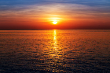 Wall Mural - sunset at ocean view, sun reflected on water