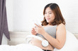 © comzeal - Pregnant women open music from smartphone with headphones for unborn baby